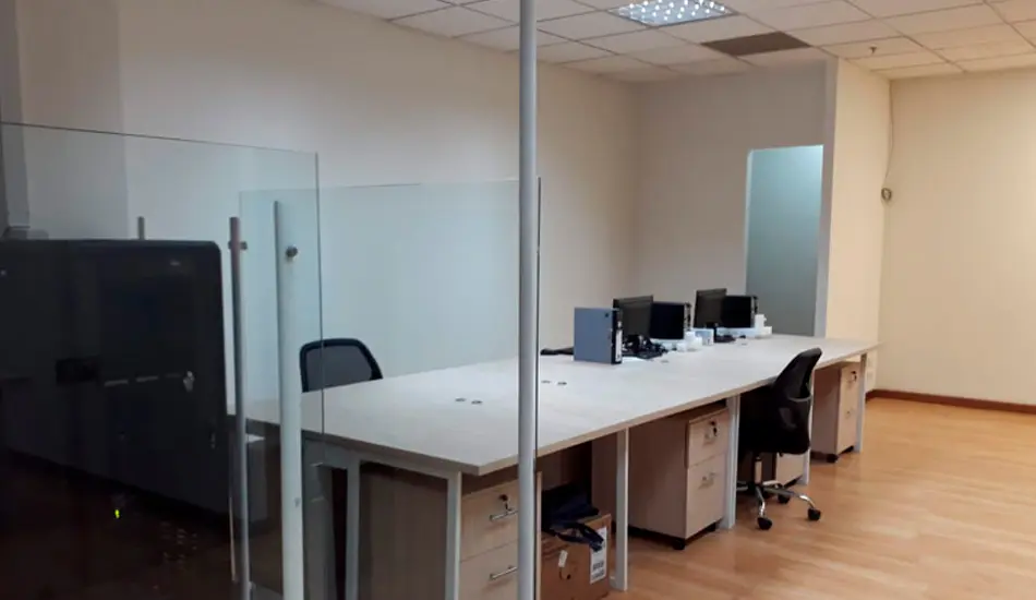 Oficina abierta remodelada con puestos de trabajo y división en vidrio