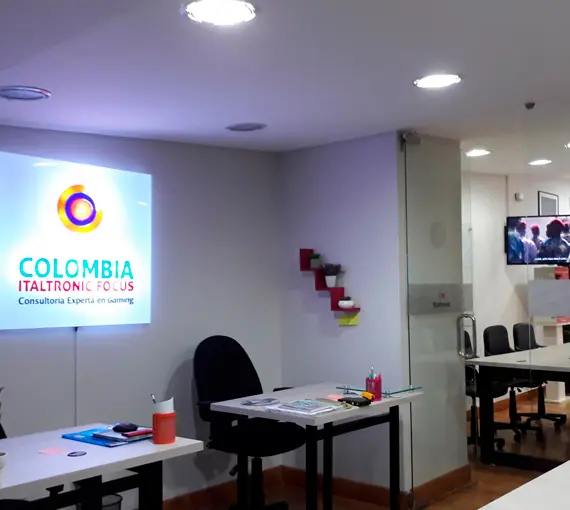 Oficina remodelada con escritorios y pantalla corporativa